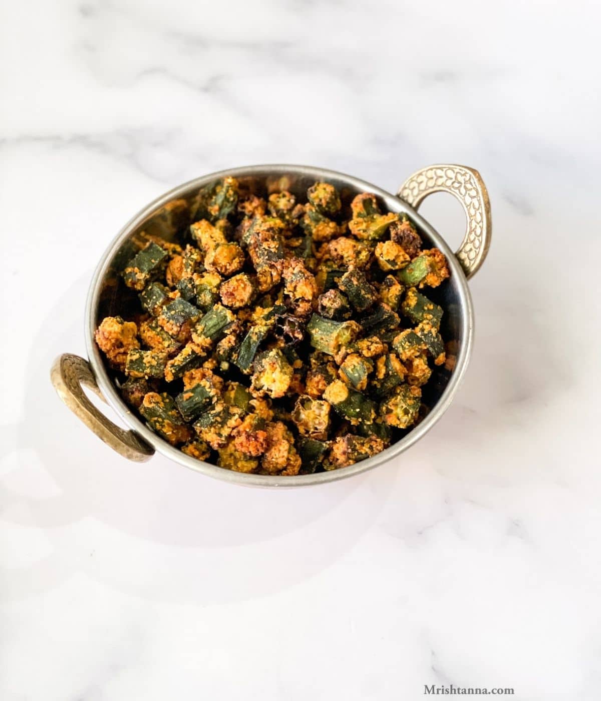 A bowl is with air fried frozen okra and its on the table.