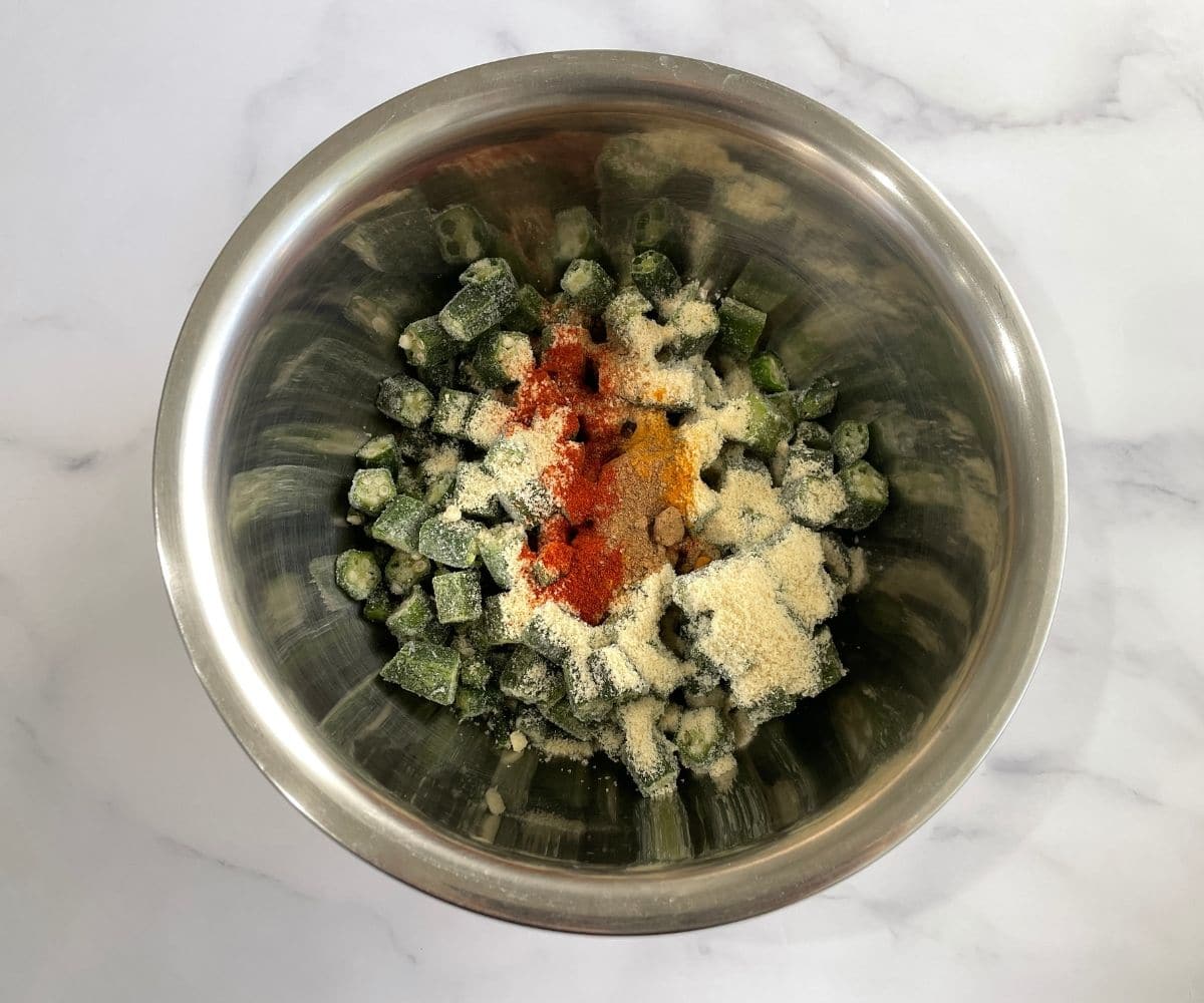 A bowl of okra, spices and almond meal is on the table.