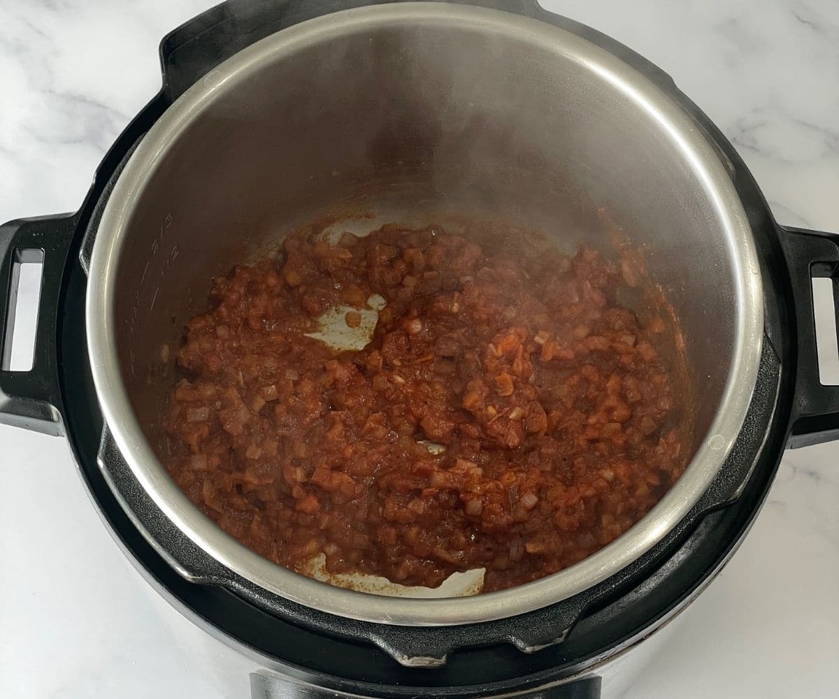 A pot is with tomato rice masala.