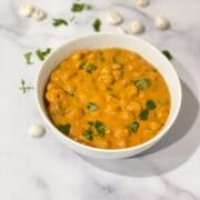 a bowl of lotus seed curry is on the table.