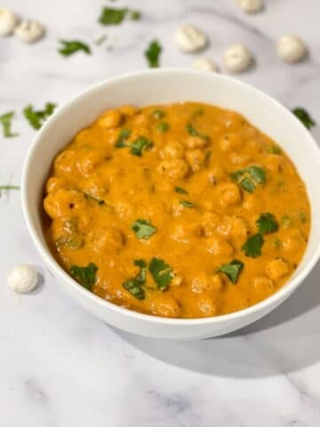 a bowl of lotus seed curry is on the table.