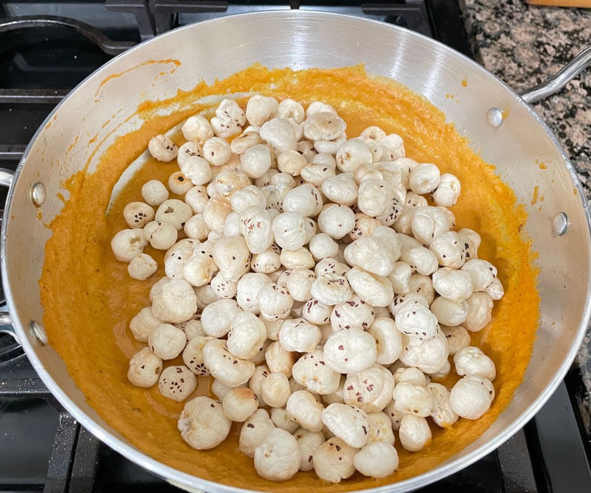 A vessel is with phool makhana curry over the stove top.