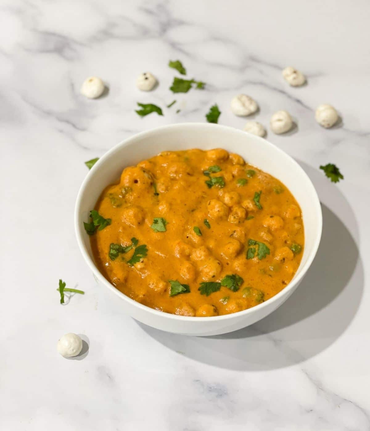 A bowl of phool makhana curry is on the table.