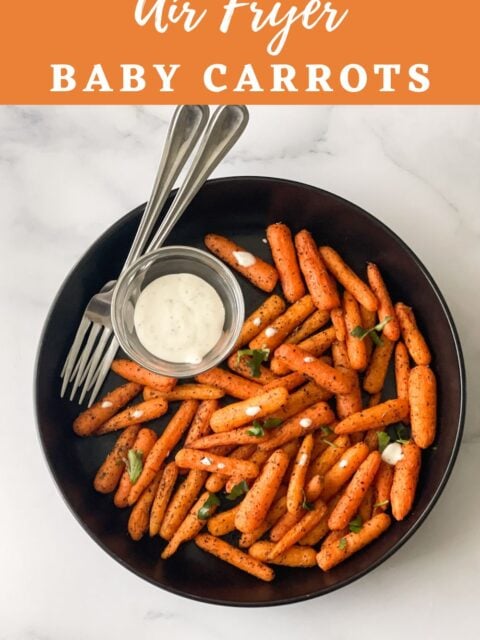 A black color plate is with air fryer baby carrots.