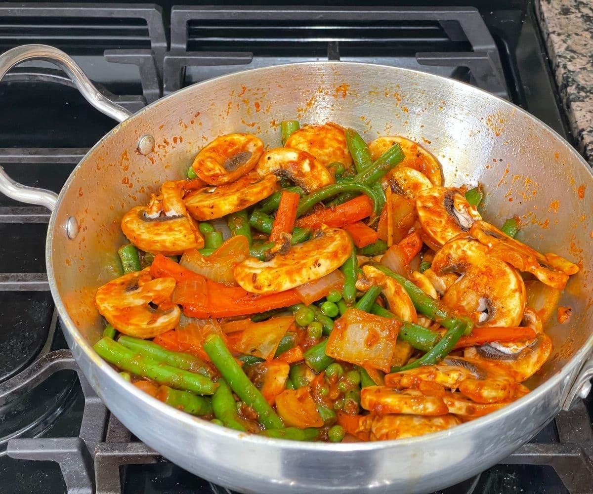 A kadai is with vegan jalfrezi over the heat.