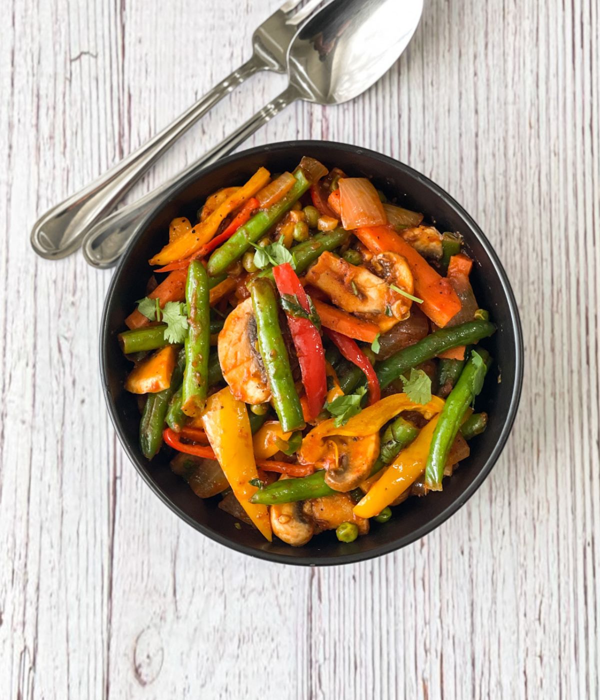 A bowl of vegan jalfrezi stir fry is on the table.