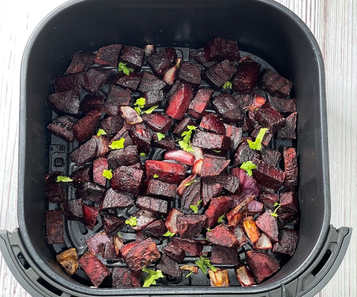 roasted beets are inside the air fryer basket.