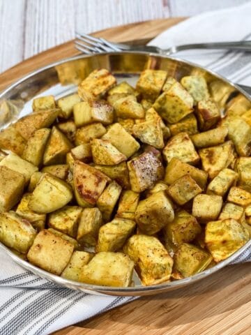 A plate is with air fried sweet potato chunks.