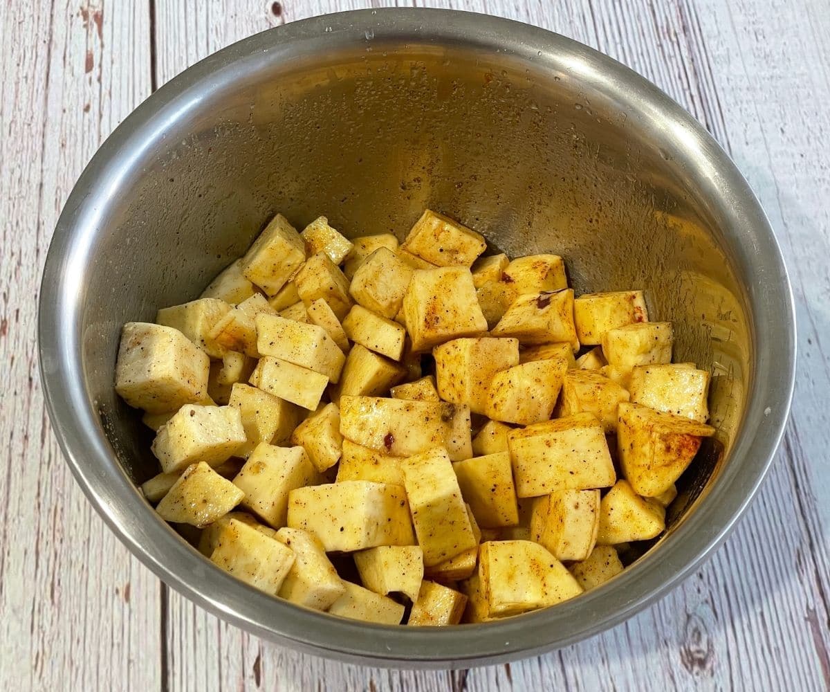 sweet potatoes are tossed over spices.