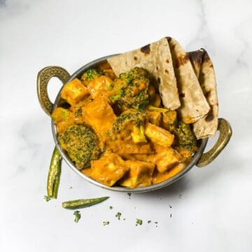 A small pot with broccoli curry and roti's.