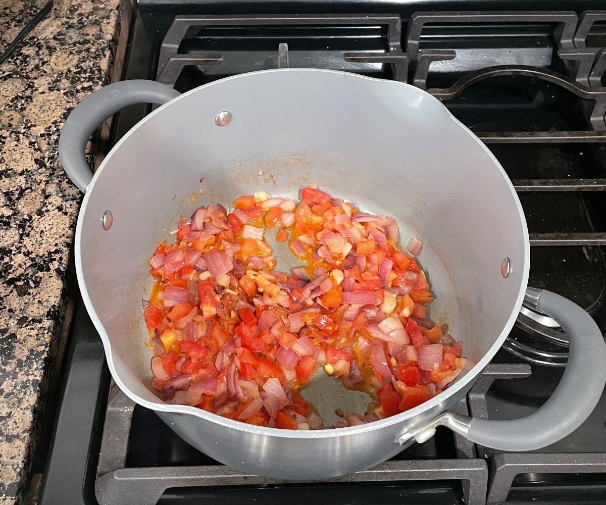 A pan is with tomatoes for cabbage curry.