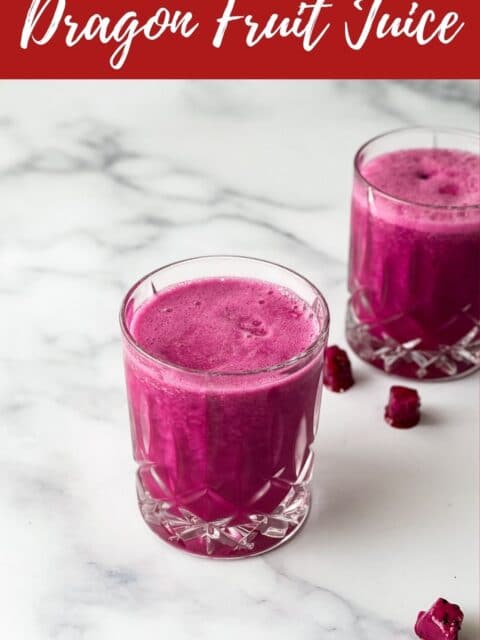 A glass of dragon fruit juice is on the table.