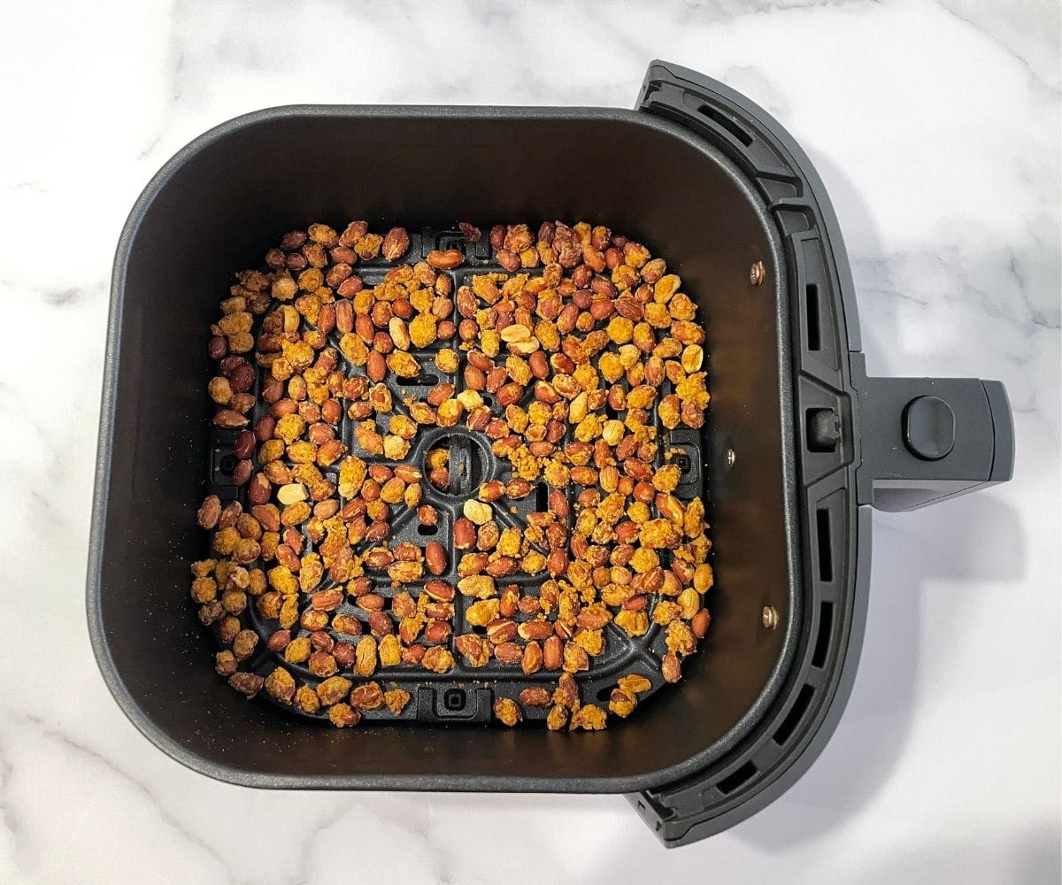 Peanut mixture is inside the air fryer basket.