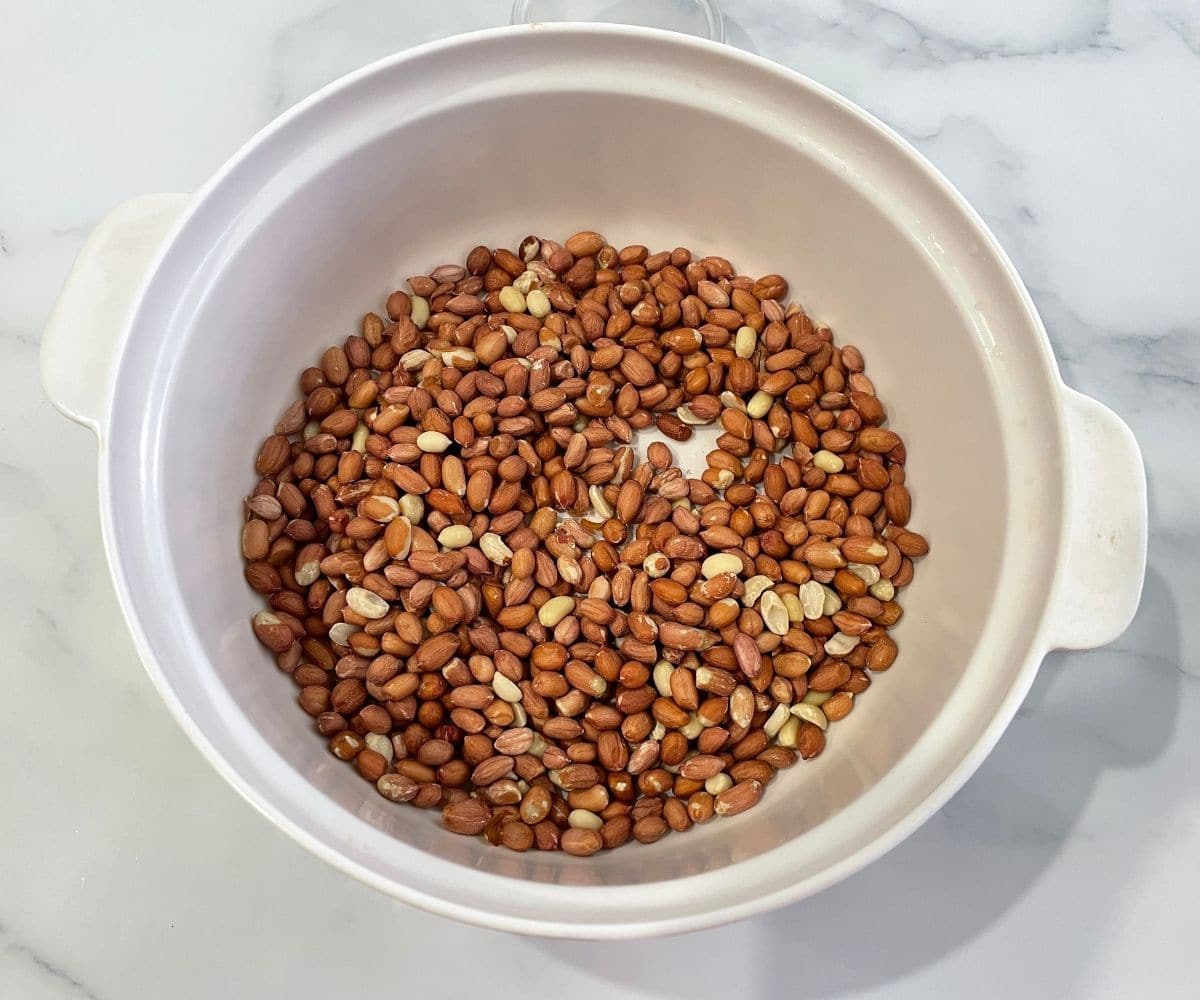 A big bowl is with raw peanuts.