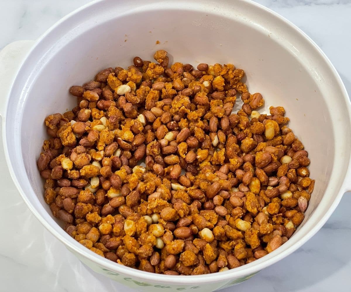 A bowl of peanuts mixture is on the table.