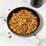 A bowl of masala peanuts are on the table.