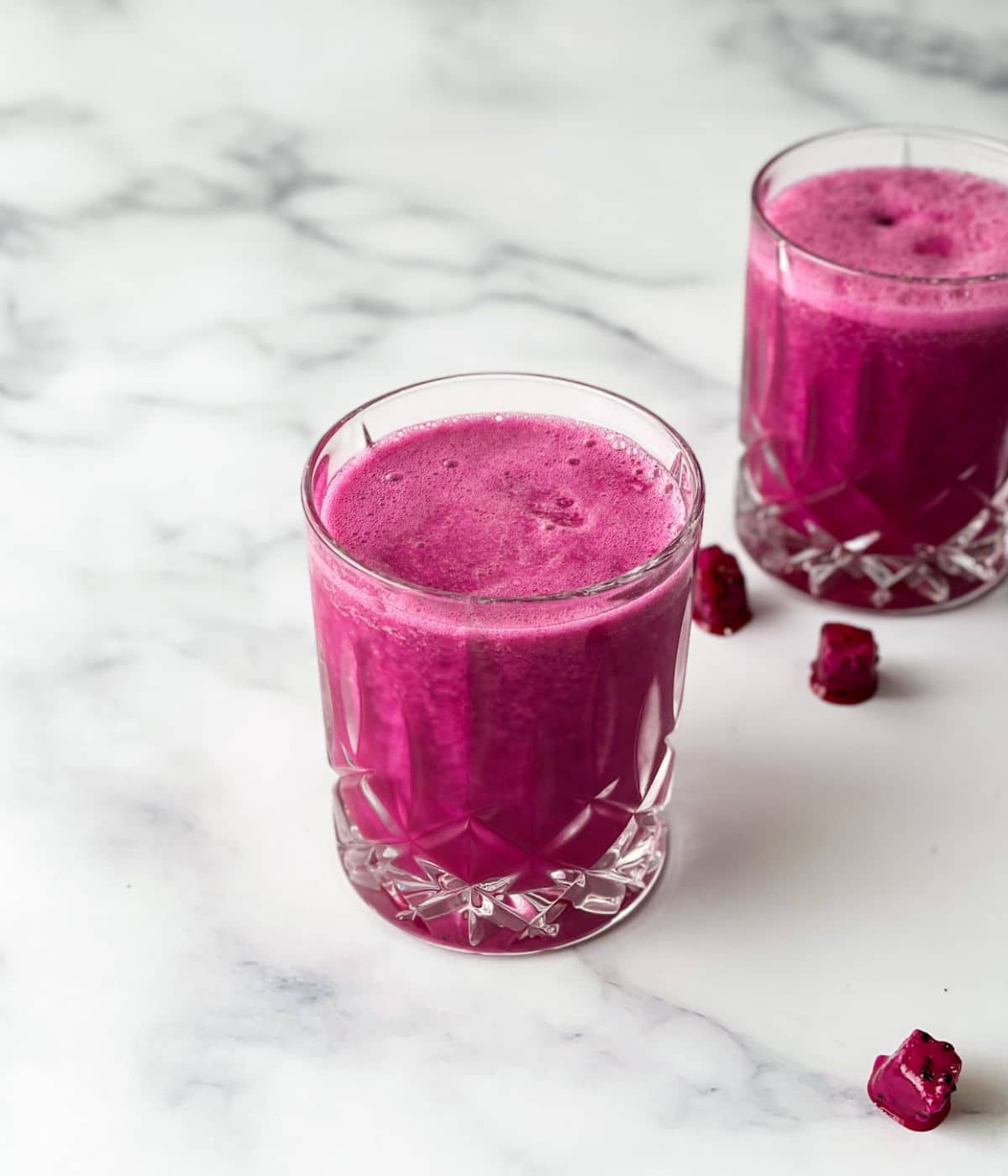 Two glasses of dragon fruit juice are on the table.