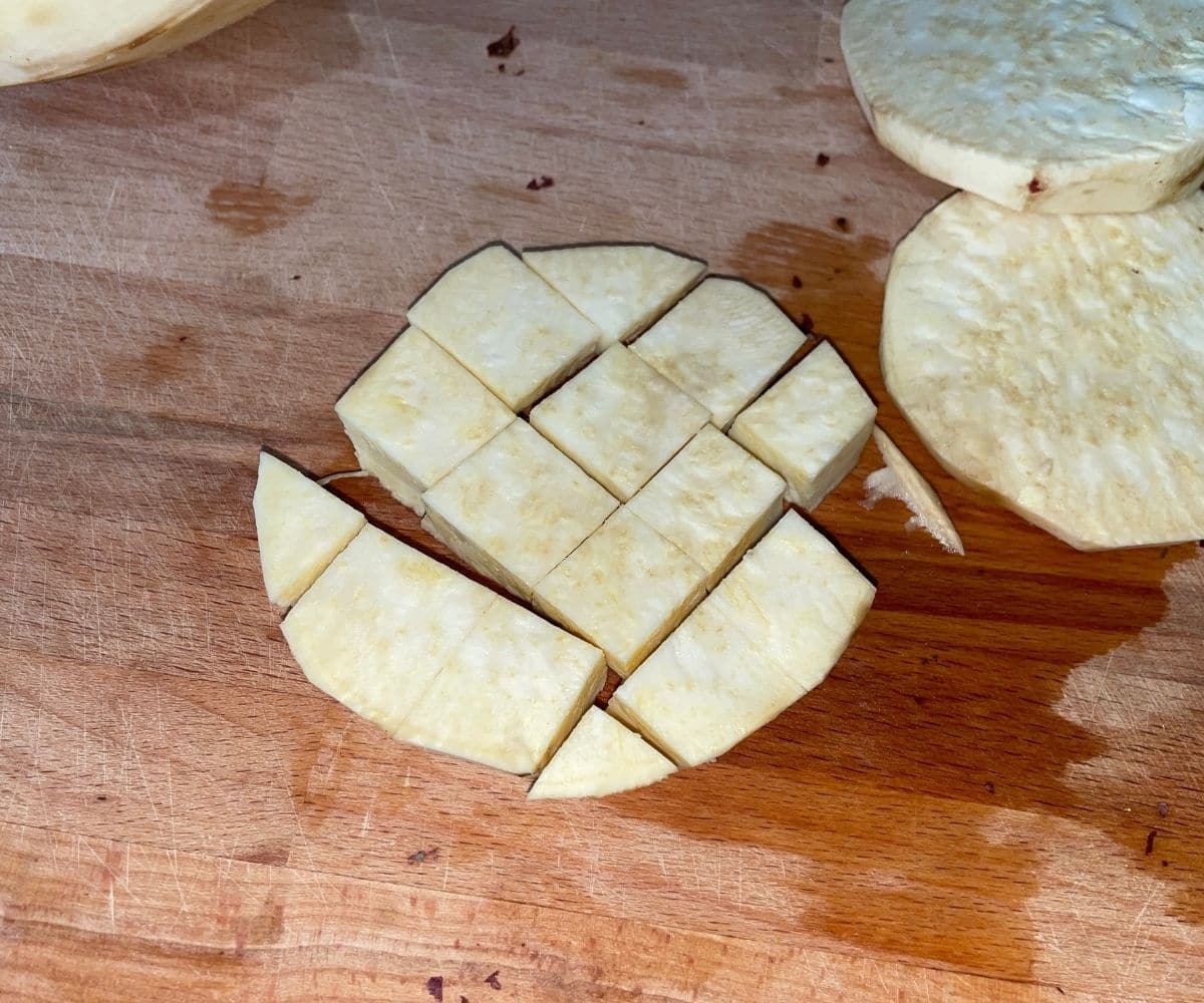 cubed and skinned sweet potato are on the cutting board. 