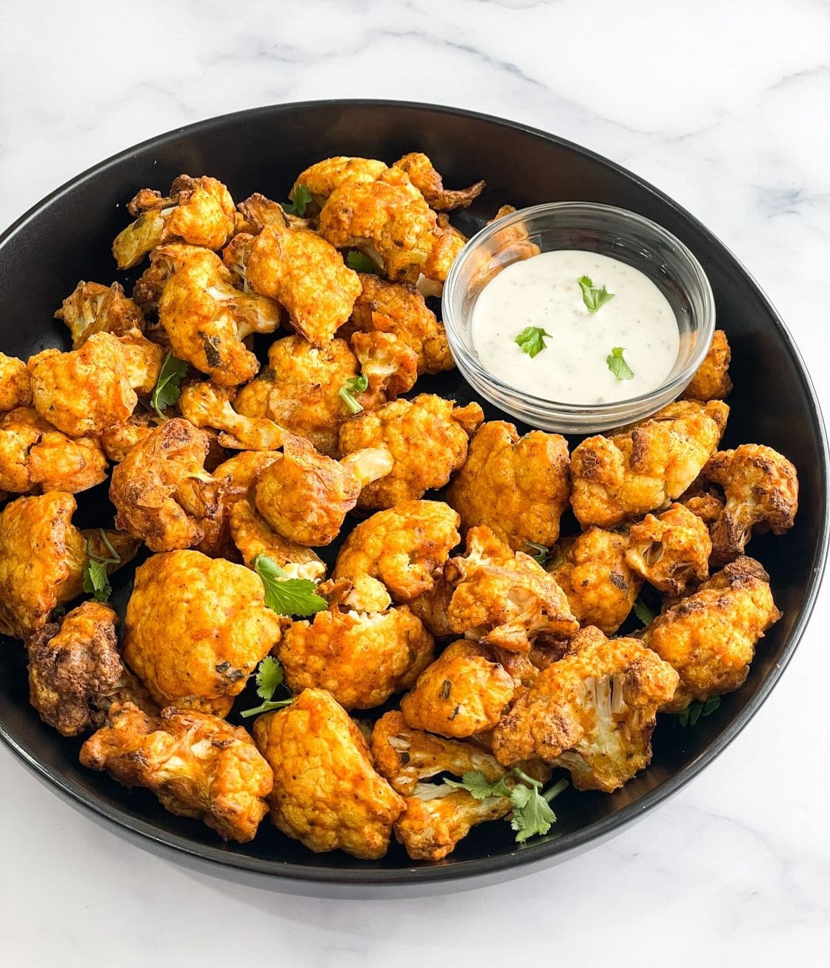 Close up shot of tandoori gobi with yogurt dip.