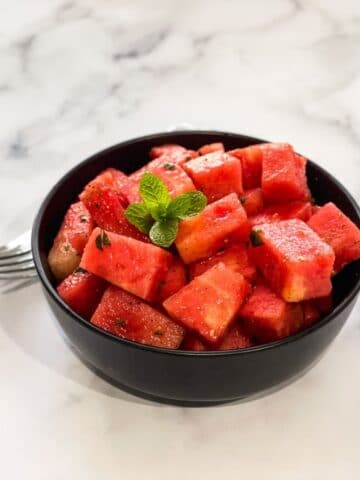 A bowl if watermelon chaat is on the table.