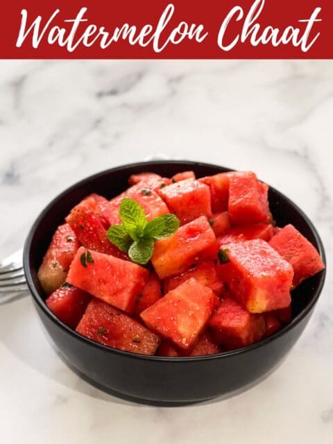 A bowl of watermelon chaat salad is on the table with forks.