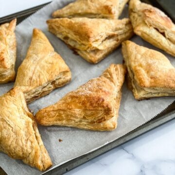 Air fried apple turnovers are placed on the baking tray.