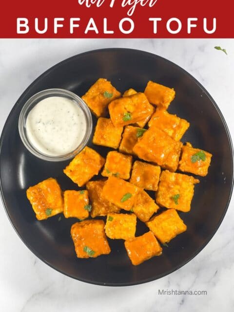 A plate of air fried buffalo tofu is with dipping vegan sauce.