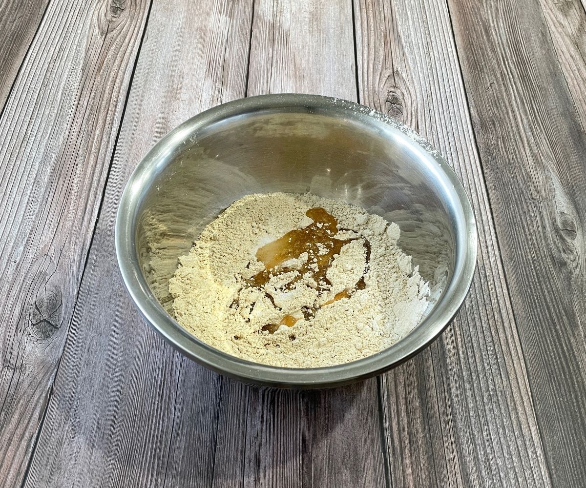 A bowl is with quinoa flour, salt and oil for roti.