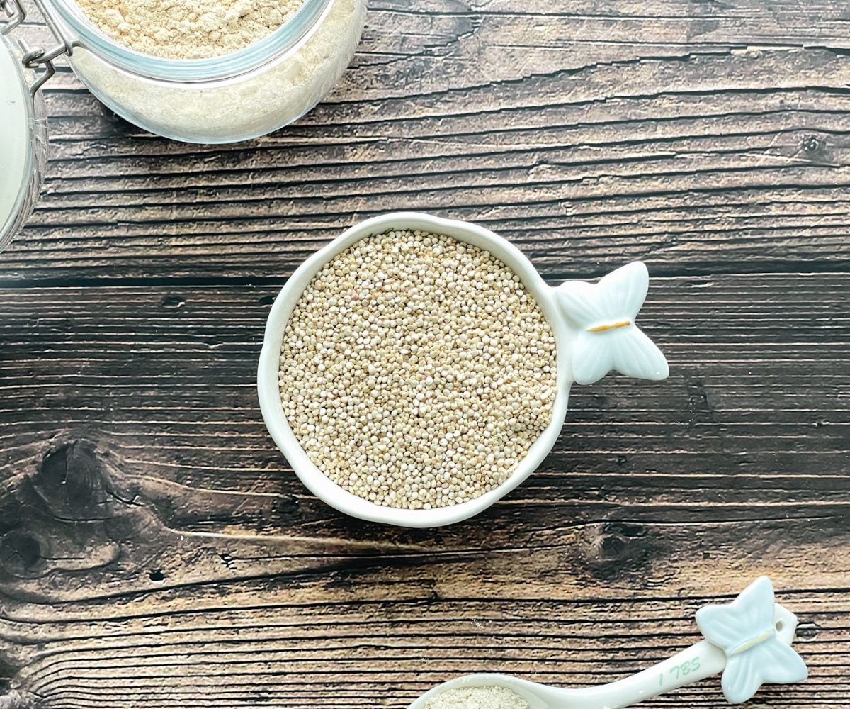 A cup is with dry quinoa on the table.