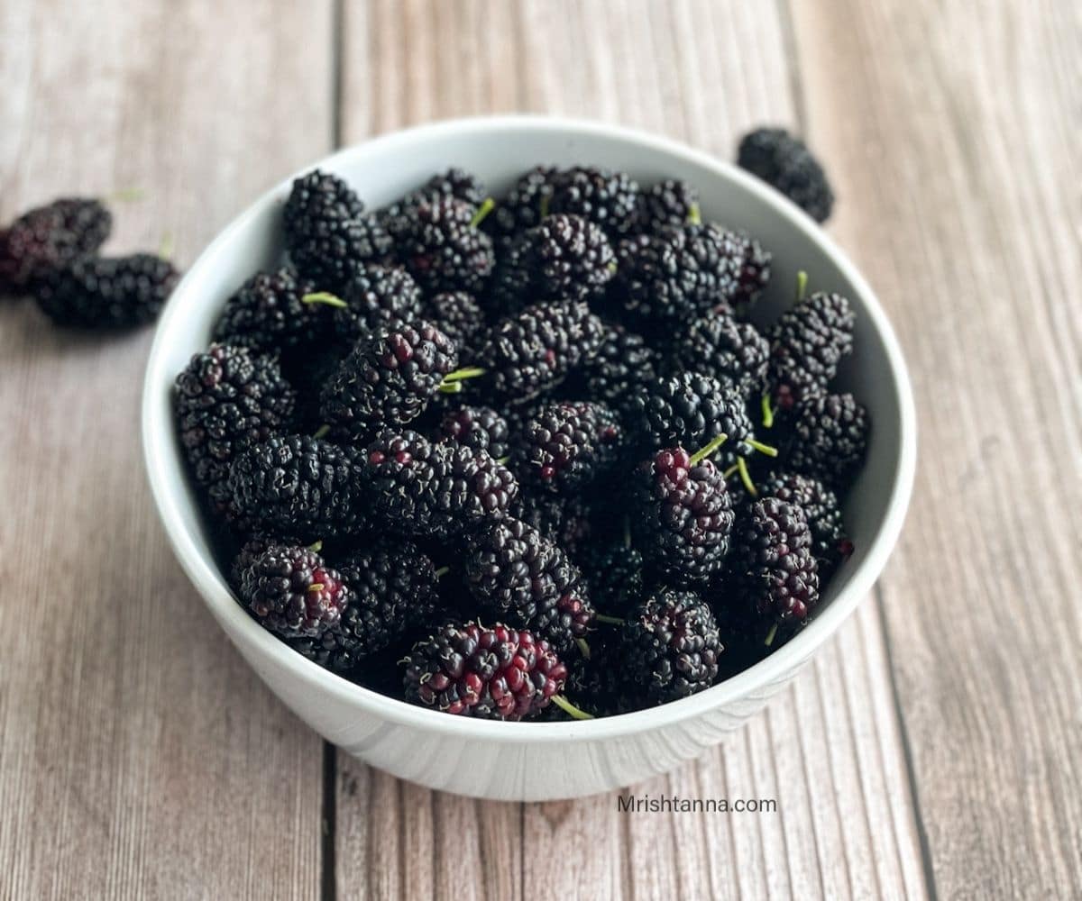 A bowl of mulberries on the table.