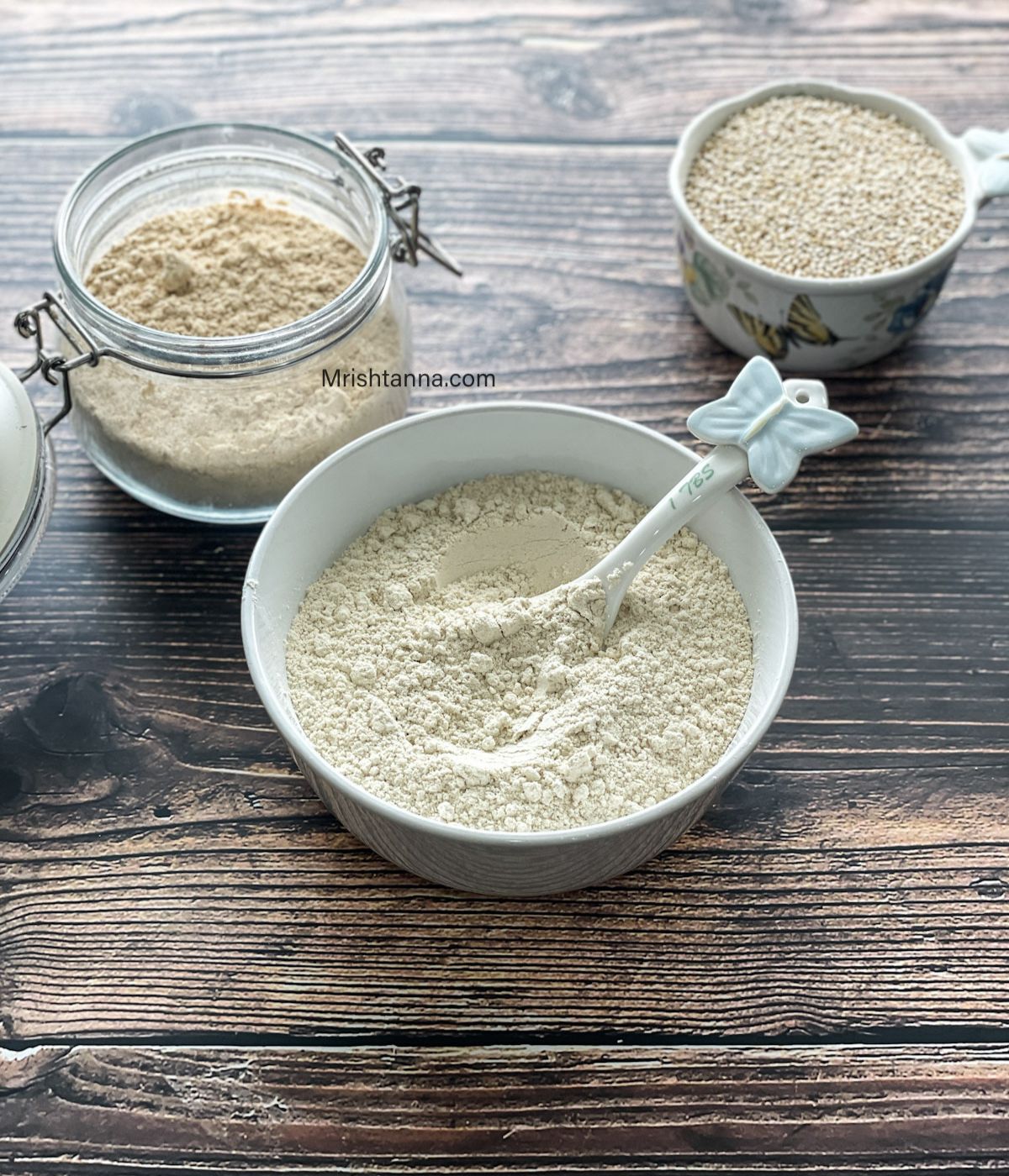 A white bowl is with quinoa flour and a spoon is inserted.