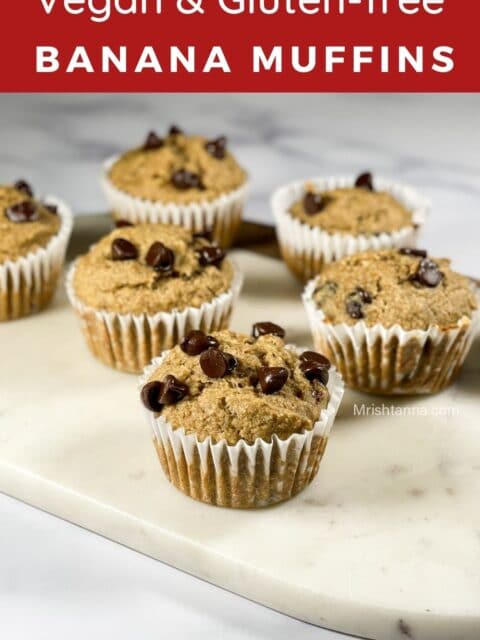 A board is filled with baked gluten free banana muffins.