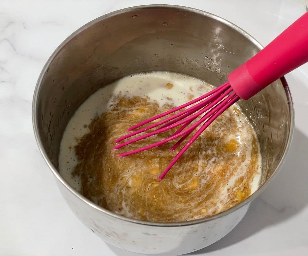 A bowl is with wet ingredients of vegan banana muffins.