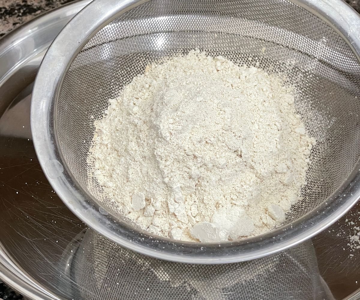 A strainer is filled with homemade quinoa flour.