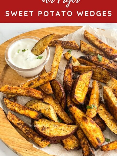 Wooden tray is with air fried sweet potato wedges and vegan dip.