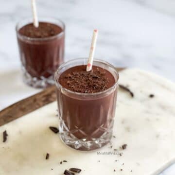 Glass of cherry smoothie are on the white marble tray.