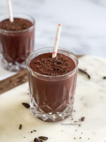 Glass of cherry smoothie are on the white marble tray.