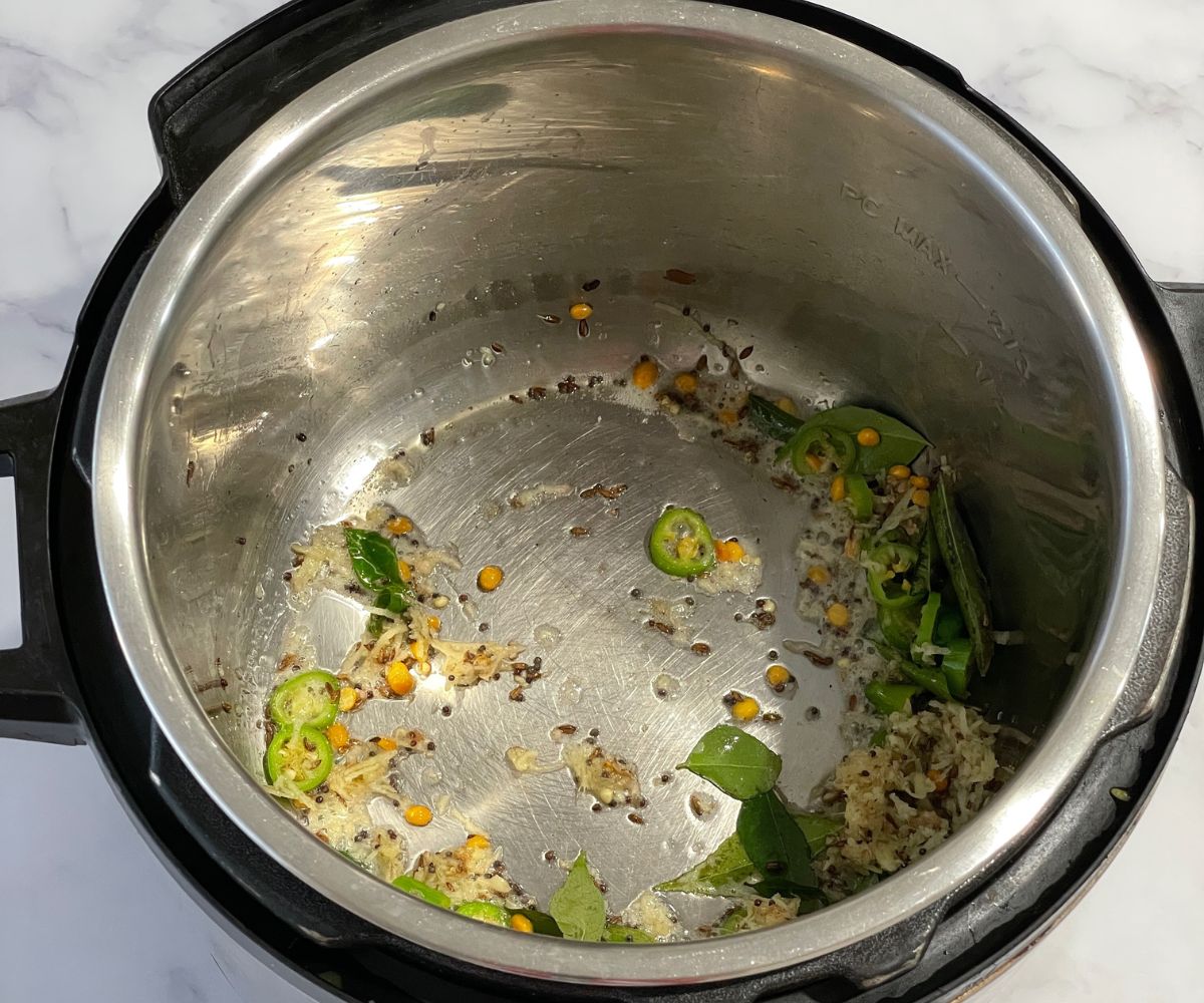 An instant pot is with spices for lemon rice.