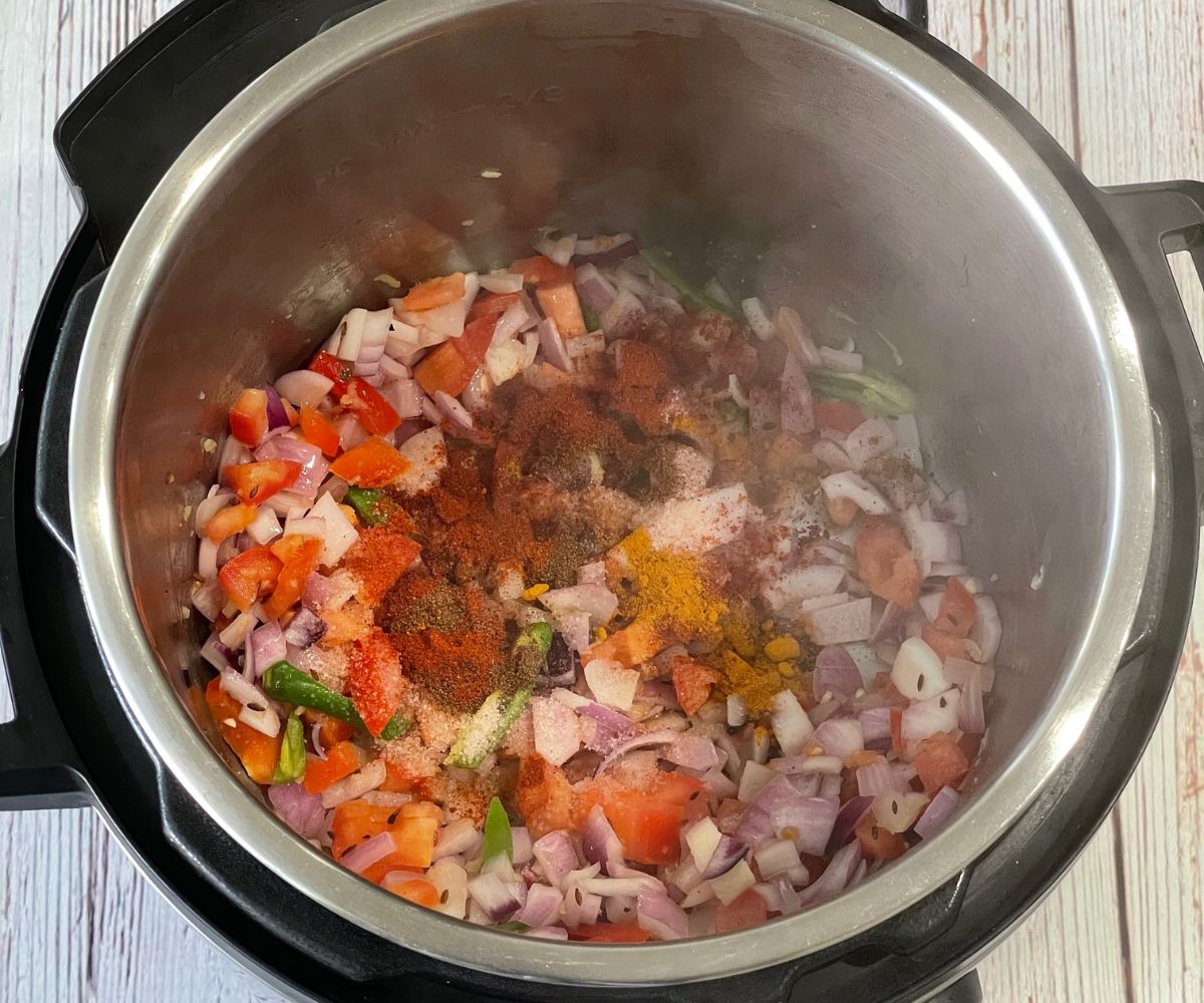 A pot is with tomatoes and spices on saute mode.