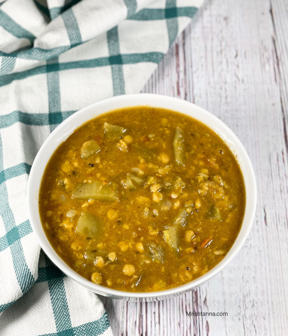 A bowl is with lauki chana dal on the table.