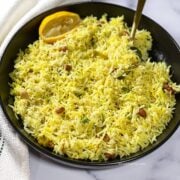 Close up of lemon rice which is on the plate with a spoon.