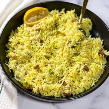 Close up of lemon rice which is on the plate with a spoon.