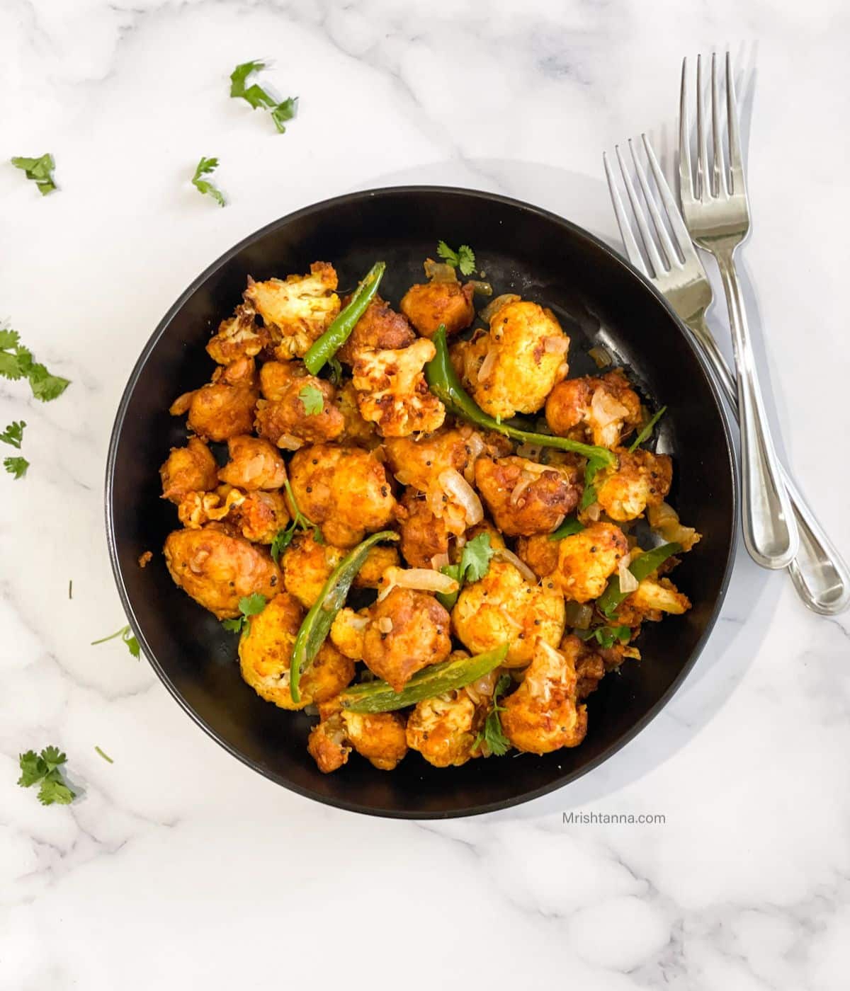 Head shot of a plate with air fryer gobi 65 and a fork.