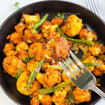 A fork is holding one of the cauliflower 65 bites.