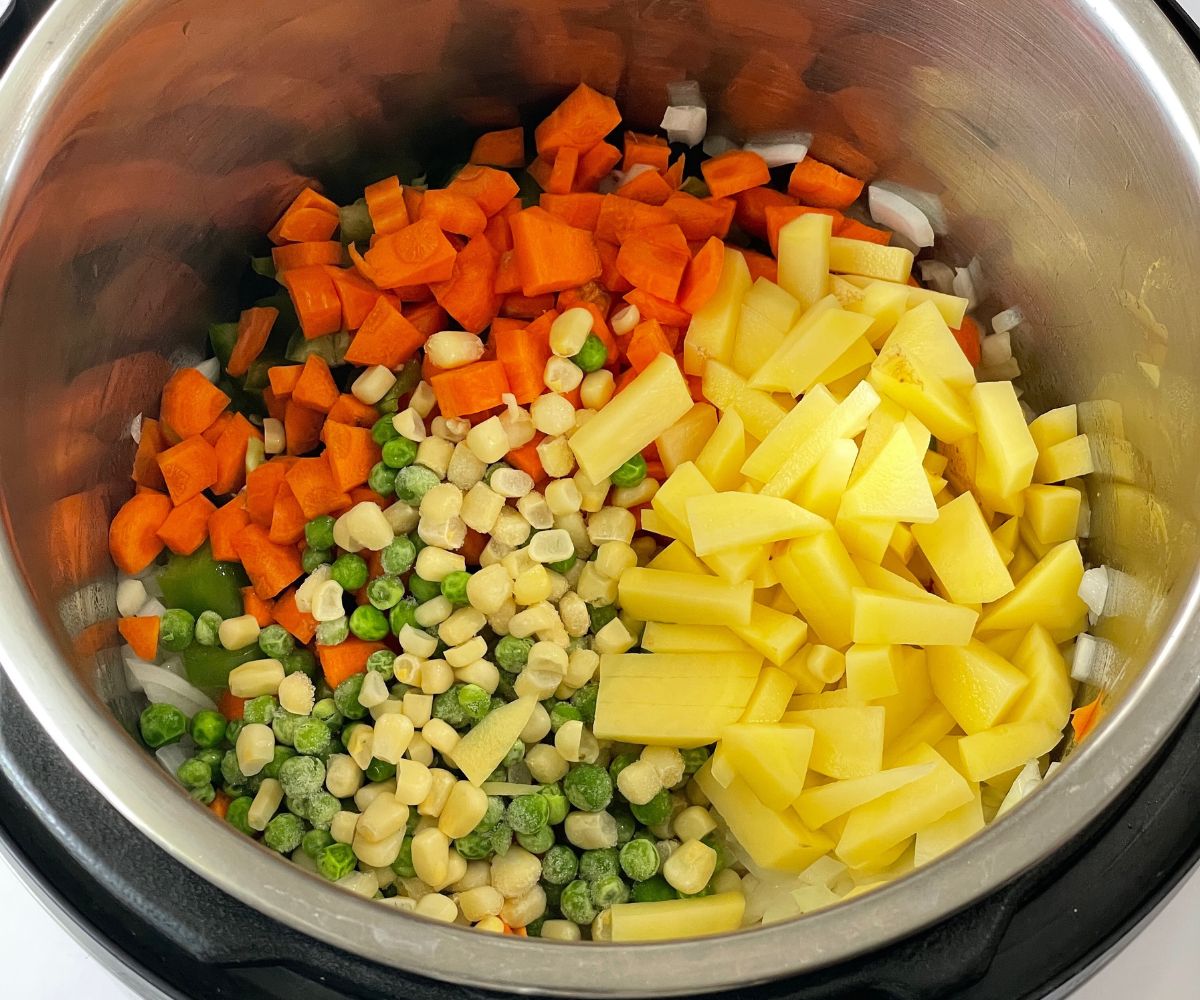 An instant pot is with vegetables on saute mode.