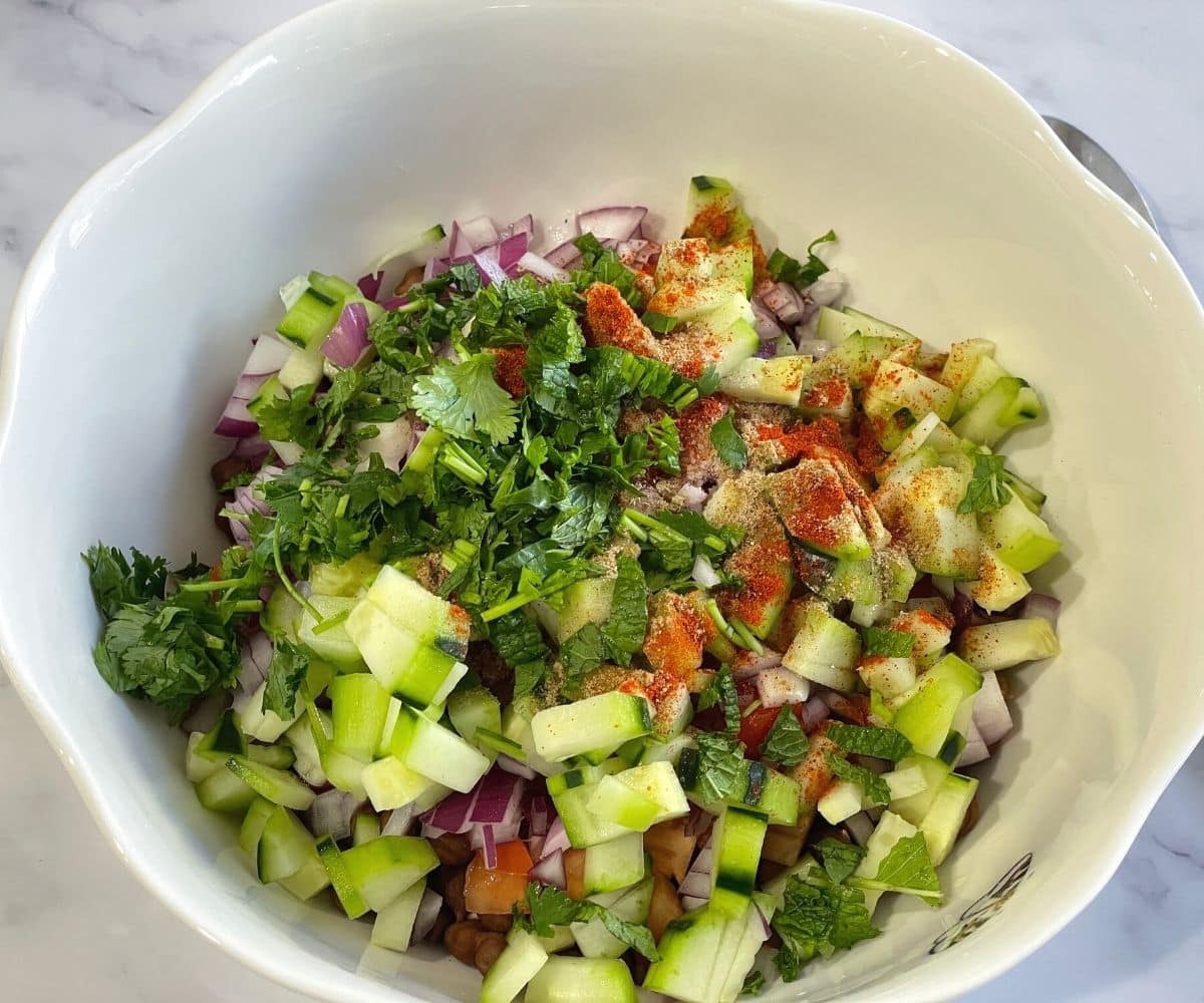 A bowl is with black chana and other ingredients for chaat.