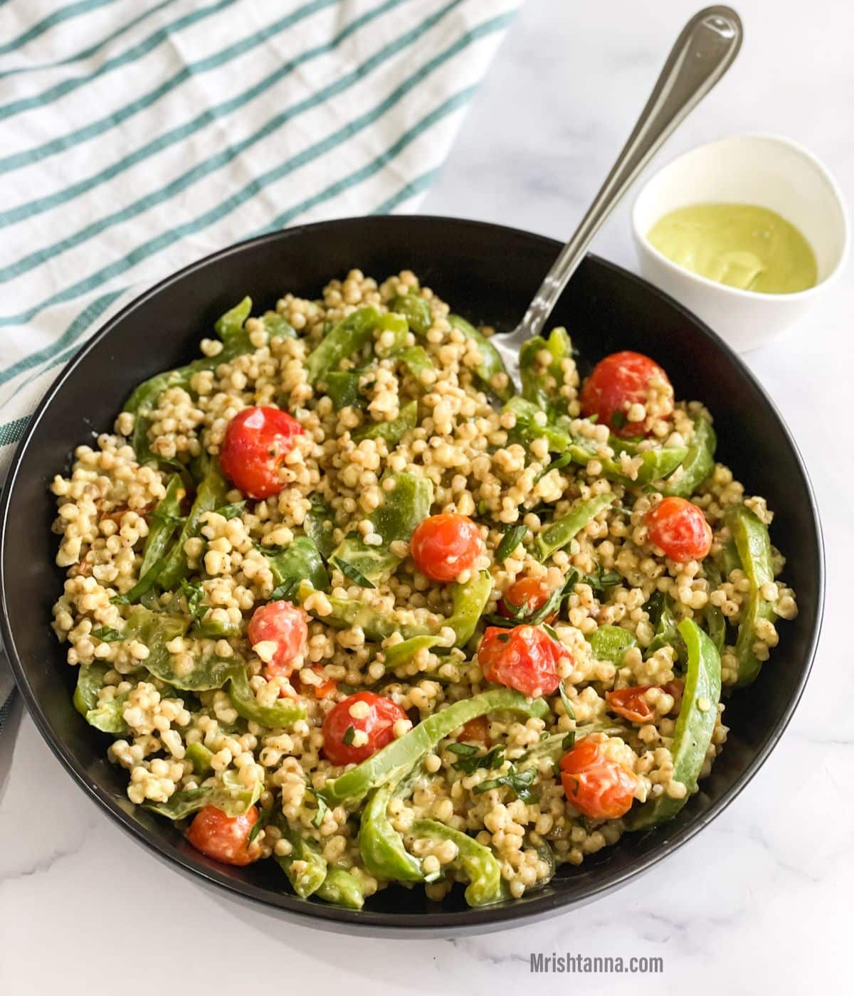 A black is with sorghum salad and fork inserted.