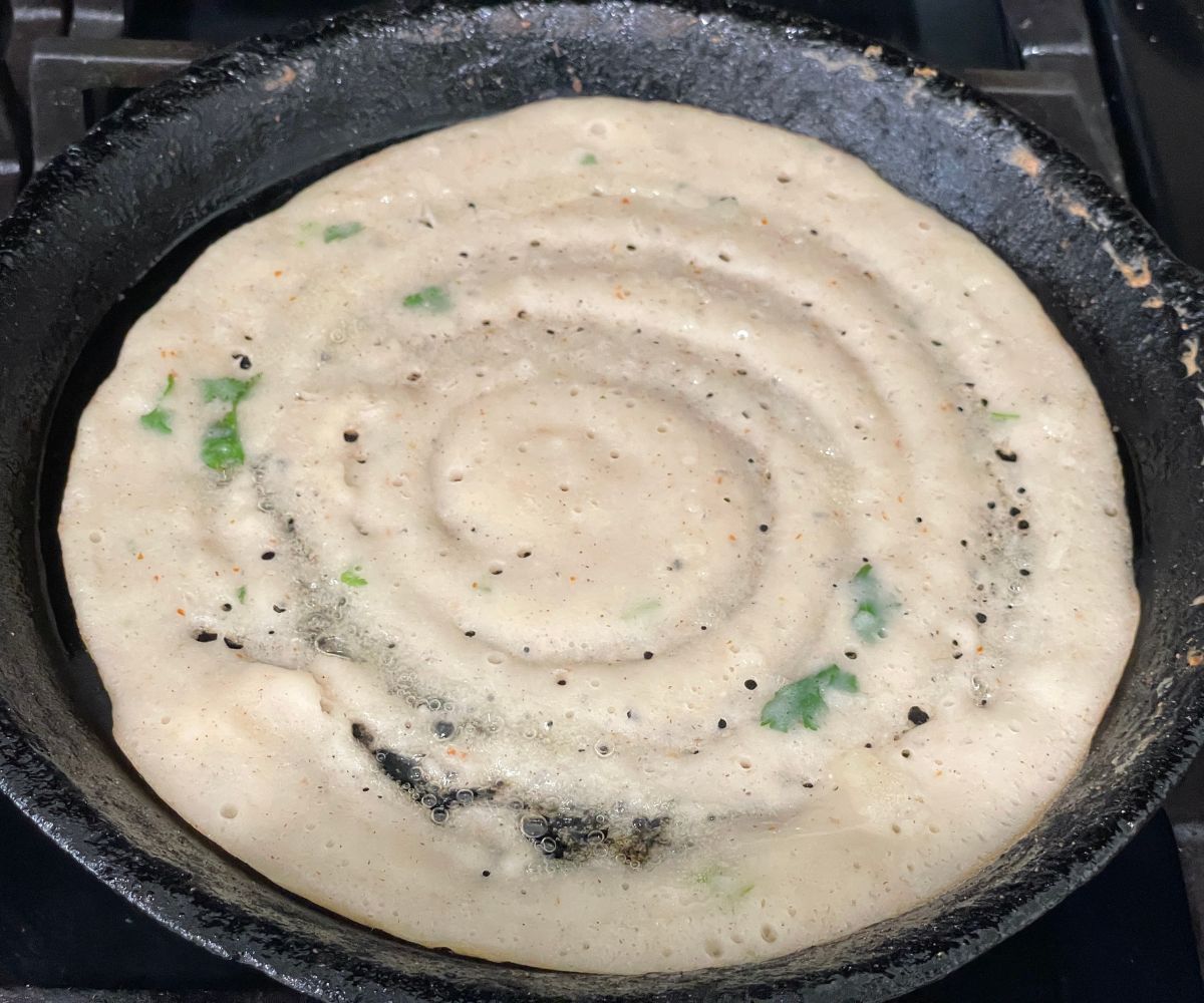 On the heated cast iron pan is with adai dosa.