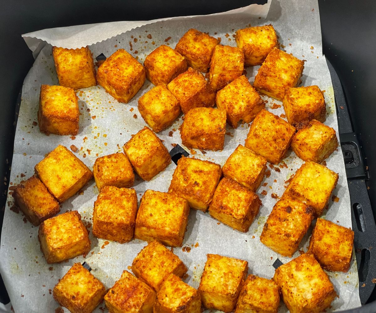 Air fried tofu paneer is inside the air fryer basket.