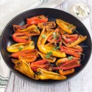 A plate of air fryer roasted mini peppers are on the table.